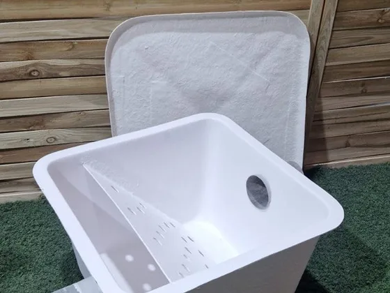 Arqueta filtro de plástico blanco con rejilla perforada que retiene toallitas antes del depósito estanco